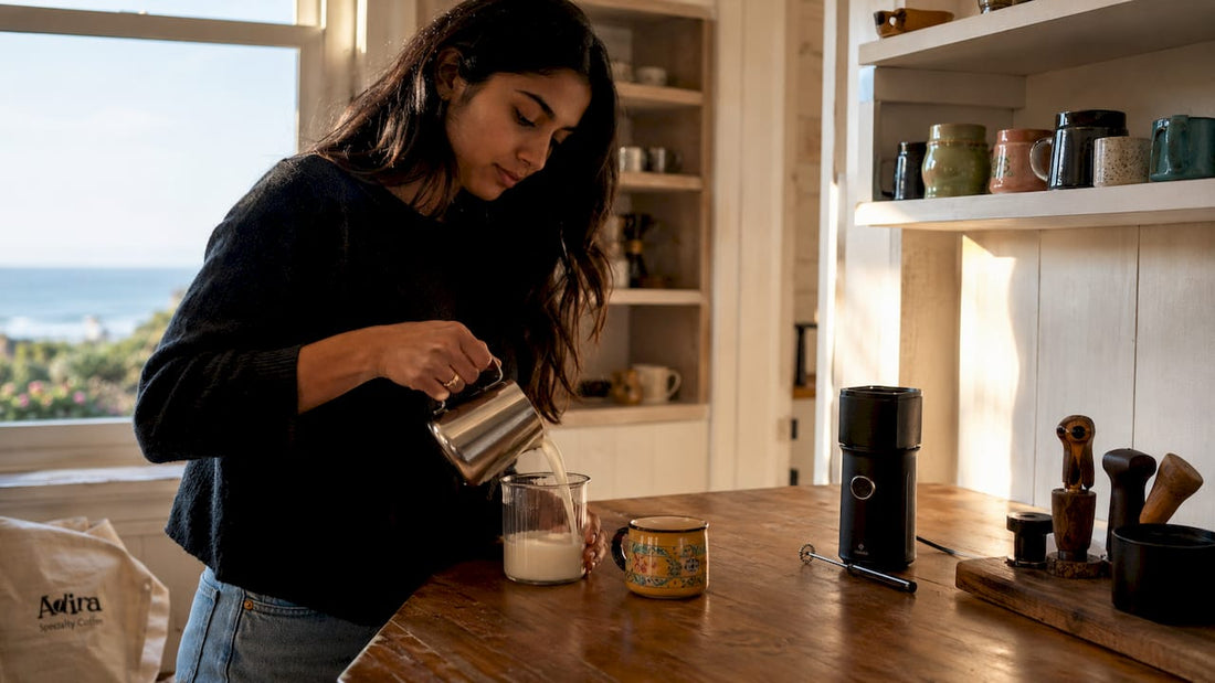 Woman frothing milk in home kitchen