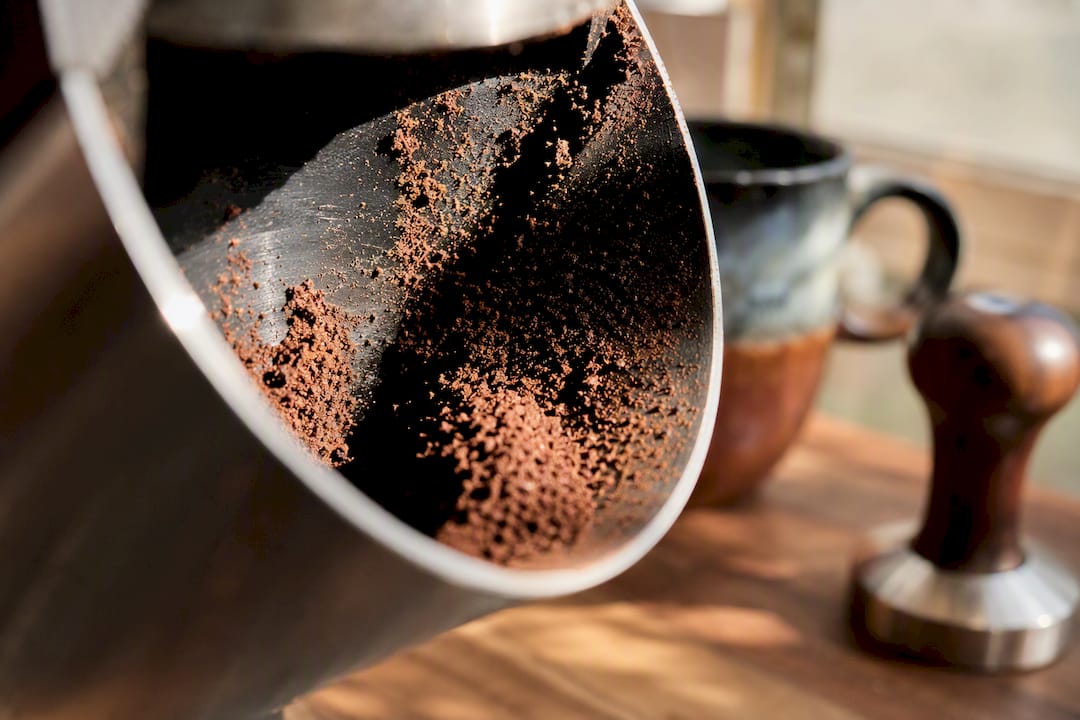 Coffee grounds stuck by static inside grinder chute