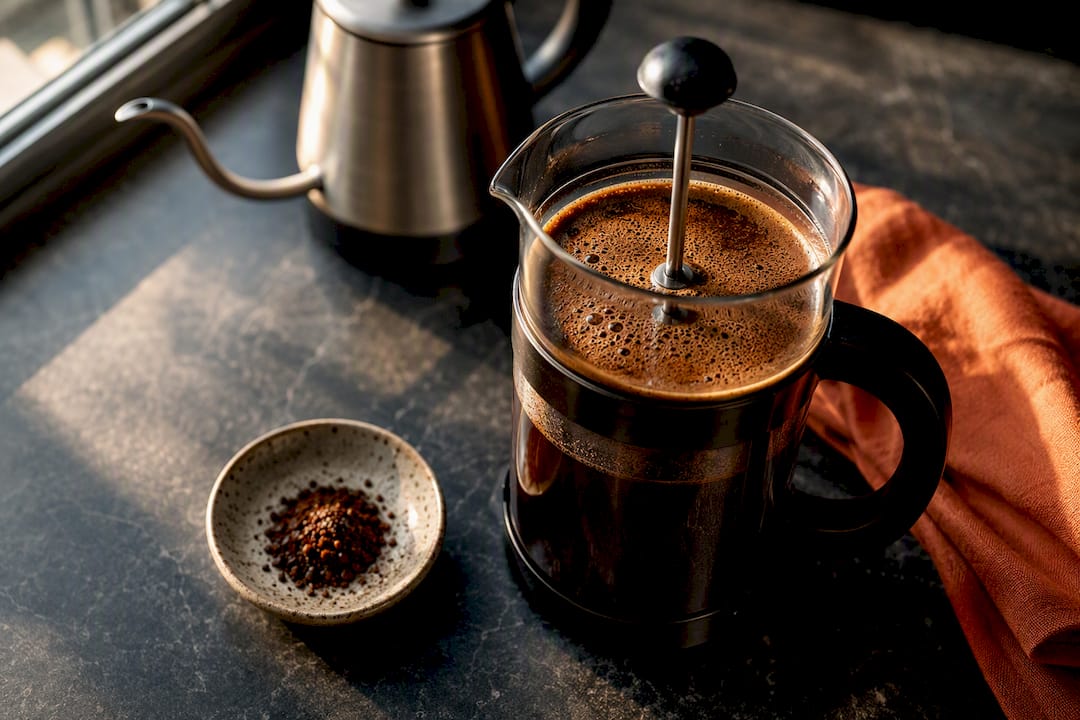 French press coffee with coarse beans nearby