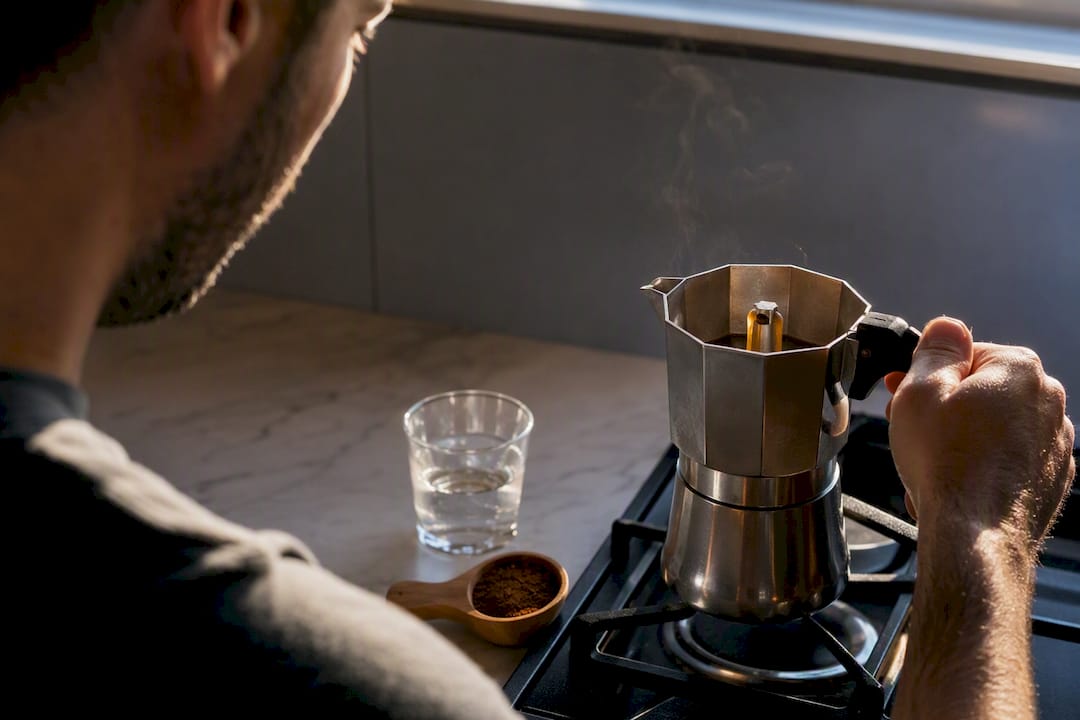 Home brewer monitoring a moka pot brew